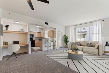 Boise apartment for rent - A modern living room with a grey carpet and a white ceiling fan.