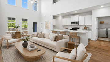 Wilmington townhouse for rent - A modern living room with a white couch and wooden furniture.
