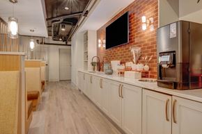 Salt Lake City apartment for rent - A modern kitchen with white cabinets and a brick wall.