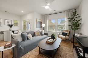 Charlotte townhouse for rent - A living room with a grey couch, a coffee table, and a piano.