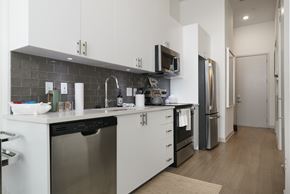 Louisville apartment for rent - A modern kitchen with white cabinets and stainless steel appliances.