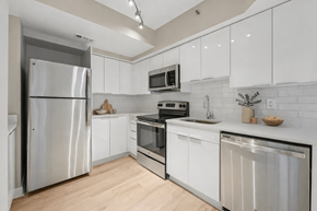 Arlington apartment for rent - A modern kitchen with white cabinets and stainless steel appliances.
