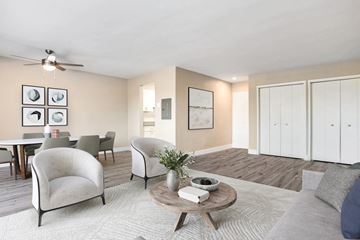 Arlington apartment for rent - A living room with a grey couch, a coffee table, and a dining table with chairs.