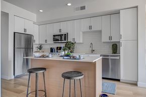 Salt Lake City apartment for rent - A kitchen with white cabinets and a wooden island.
