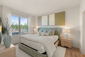 Charlotte apartment for rent - A bedroom with a large bed and a window with blinds.