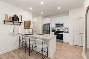 Charlotte apartment for rent - A kitchen with white cabinets and a black and white bar stool.