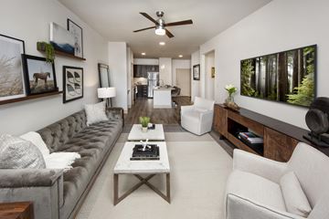 Madison apartment for rent - A living room with a grey couch, a white coffee table, and a painting of a forest on the wall.