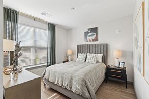 Fredericksburg apartment for rent - a bedroom with a bed and a large window