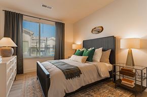 Firestone apartment for rent - A bedroom with a large bed and a window with blinds.