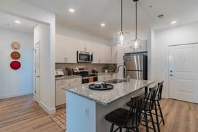 Firestone apartment for rent - A kitchen with a granite countertop and a refrigerator.