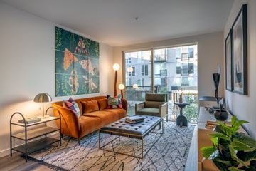 Seattle apartment for rent - A living room with a large orange sofa and a painting on the wall.