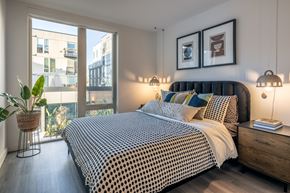 Seattle apartment for rent - A bedroom with a large bed and a view of the city.