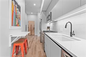 Scottsdale apartment for rent - a kitchen with white cabinets and a sink and a counter top with orange stools