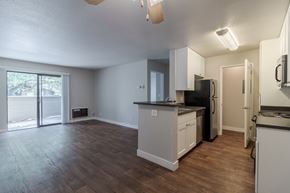 Morgan Hill apartment for rent - A kitchen with white cabinets and a black fridge.