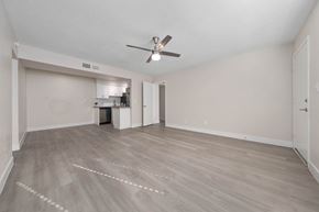 Phoenix apartment for rent - A room with a ceiling fan and light fixture, and a kitchenette in the background.