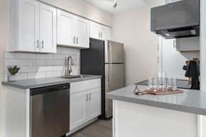 Phoenix apartment for rent - A kitchen with white cabinets and a black refrigerator.