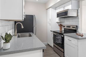 Phoenix apartment for rent - A modern kitchen with a black oven and white cabinets.