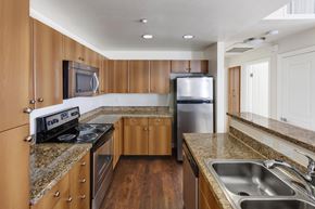 San Jose apartment for rent - A kitchen with wooden cabinets and stainless steel appliances.