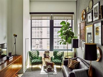 New York apartment for rent - A living room with a green chair and a brown leather couch.