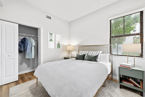 Miami apartment for rent - A bedroom with a large bed and a window with blinds.
