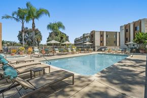 San Diego apartment for rent - A resort style pool with lounge chairs and umbrellas.