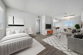 Avondale apartment for rent - A modern bedroom with a large bed and a living area with a couch.