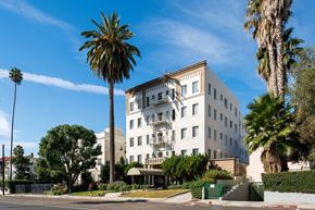 Los Angeles apartment for rent - White building with palm trees in front of it at North Kingsley, Los Angeles, CA, 90027