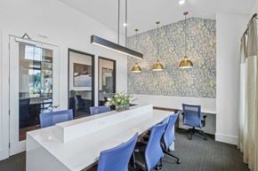 Mcdonough apartment for rent - A conference room with a long white table and blue chairs.
