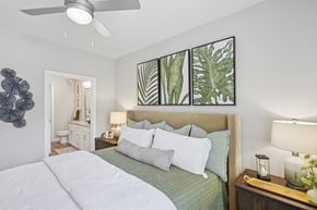 Mcdonough apartment for rent - A bedroom with a large bed and a ceiling fan.