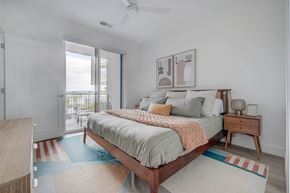 South Salt Lake apartment for rent - A bedroom with large bed and nightstand at One Burton new luxury apartments in Salt Lake City.
