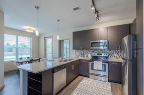 Littleton apartment for rent - an open kitchen with stainless steel appliances and a granite counter top