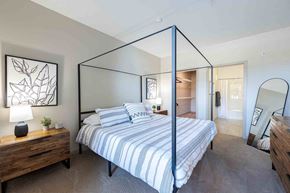 Littleton apartment for rent - A bedroom with a four poster bed and a wooden nightstand.