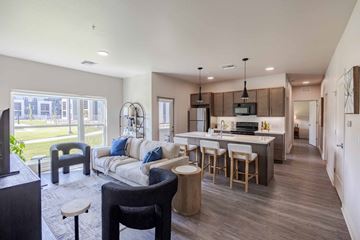 Wichita apartment for rent - A modern kitchen with a bar stool and a dining table.