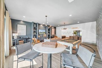 Destin apartment for rent - A modern living room with a pool table and a dining table.