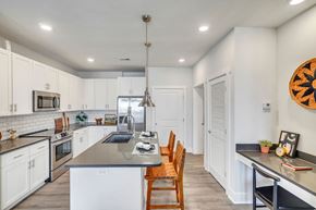 Destin apartment for rent - Contemporary apartment kitchen with white cabinetry, island and pendant lighting