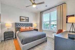 Destin apartment for rent - Modern bedroom with upholstered bed, ceiling fan and large windows