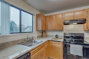 Vancouver apartment for rent - A kitchen with wooden cabinets and a black stove top oven at Aspenridge Apartments,Vancouver, WA
