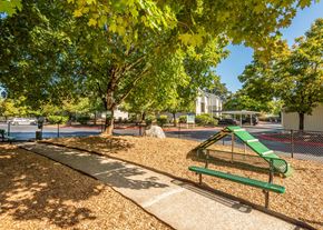 Vancouver apartment for rent - A playground with a green slide and a bench at Aspenridge Apartments, Vancouver, WA
