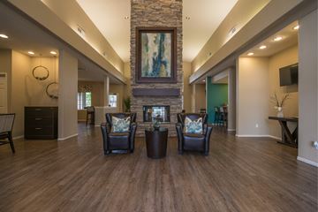 Flagstaff apartment for rent - A living room with a stone fireplace and a painting above it.