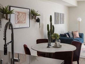 Long Beach apartment for rent - A dining room with a table surrounded by chairs and a cactus plant on the table.