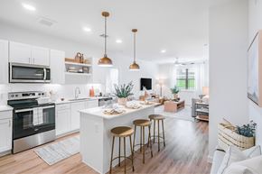 Austin apartment for rent - A modern kitchen with white cabinets and a center island.