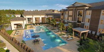 Humble apartment for rent - A large outdoor swimming pool surrounded by lounge chairs and umbrellas.