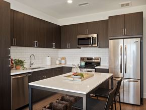 Superior apartment for rent - a kitchen with stainless steel appliances and a white counter top