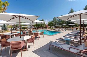 Highlands Ranch apartment for rent - A poolside area with tables and chairs and umbrellas.