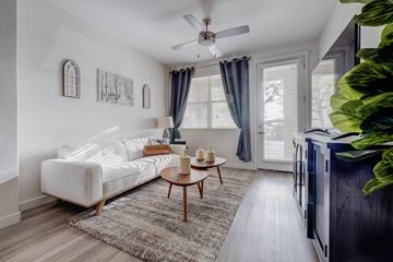 Farmington apartment for rent - A living room with a white couch and a ceiling fan.