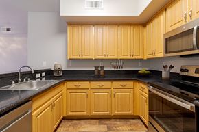 San Ramon apartment for rent - A kitchen with wooden cabinets and black countertops.