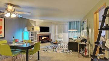 Everett apartment for rent - A living room with a fireplace, a dining table and chairs, and a television.