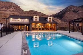 Ogden townhouse for rent - A large house with a pool in the foreground and mountains in the background.