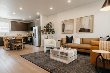 Ogden townhouse for rent - A modern living room with a white sofa, a coffee table, and a dining table with chairs.