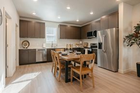 Ogden townhouse for rent - A kitchen with a table and chairs in the middle of the room.